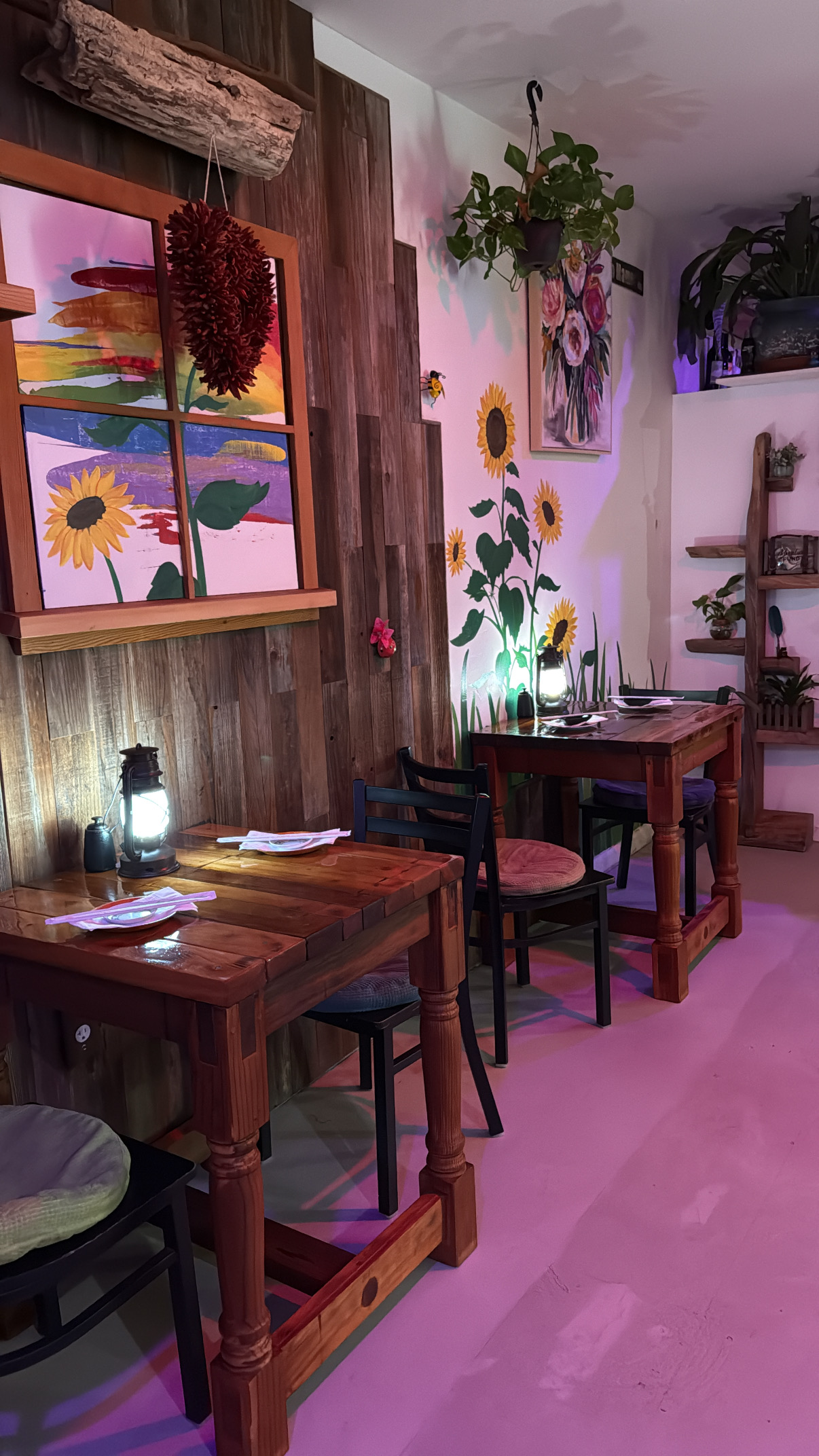 Wooden tables, lanterns and sunflower artwork inside The Buzz Sushi