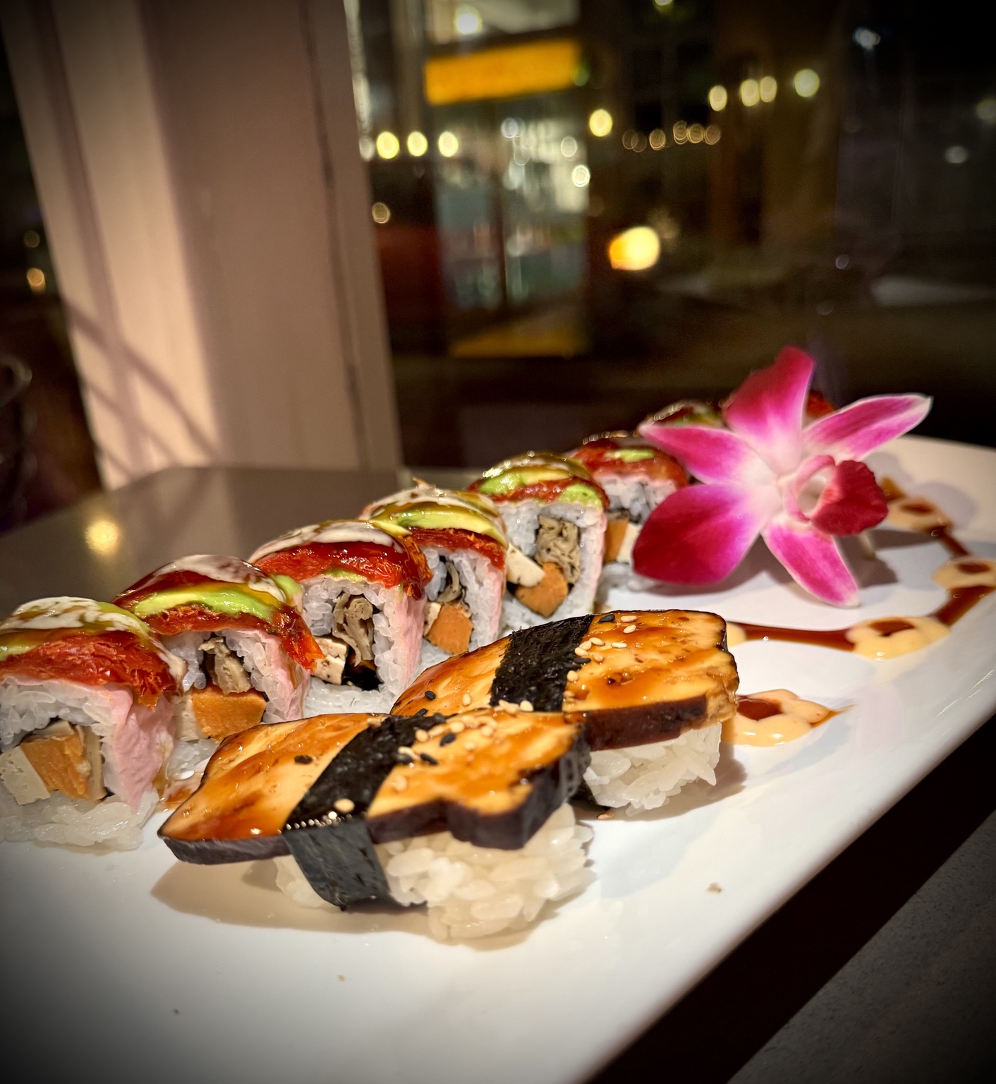 Sushi rolls and nigiri with an orchid